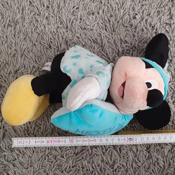 Mickey Mouse plush toy in blue glow-in-the-dark pajamas with a cushion