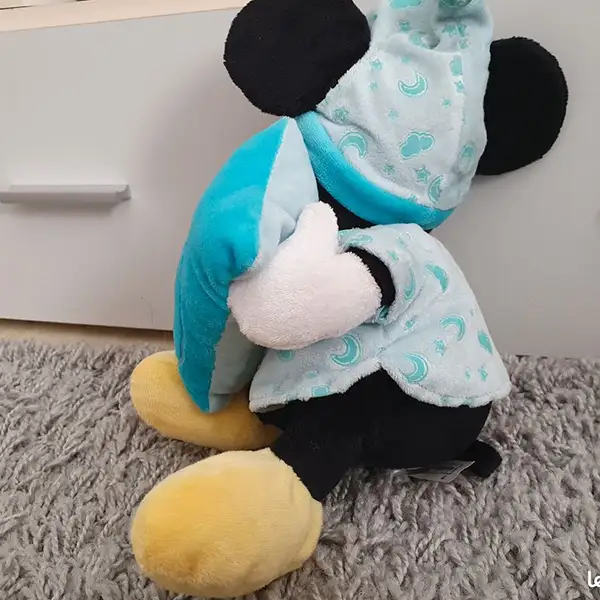 Mickey Mouse plush toy in blue glow-in-the-dark pajamas with a cushion